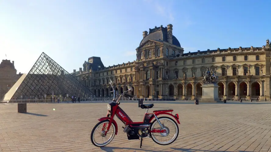 visite guidée de Paris en scooter devant la pyramide du Louvre